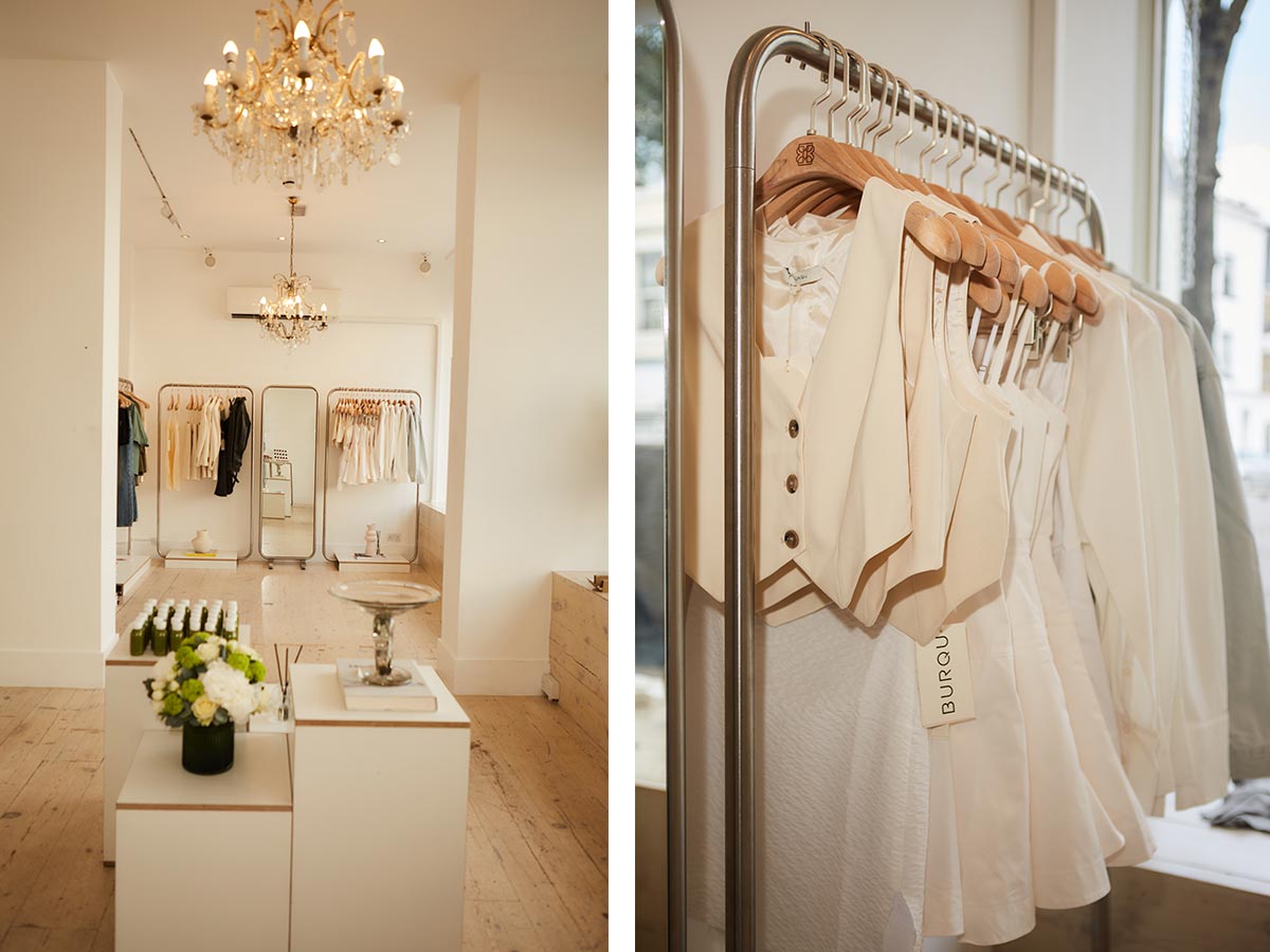 Elegant boutique interior with clothing and chandelier.