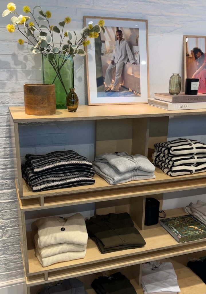 Fashion store shelf with clothes and framed photographs