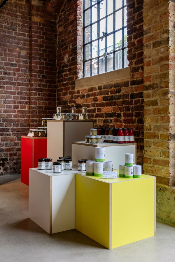 Colorful display of jars in brick-walled boutique.