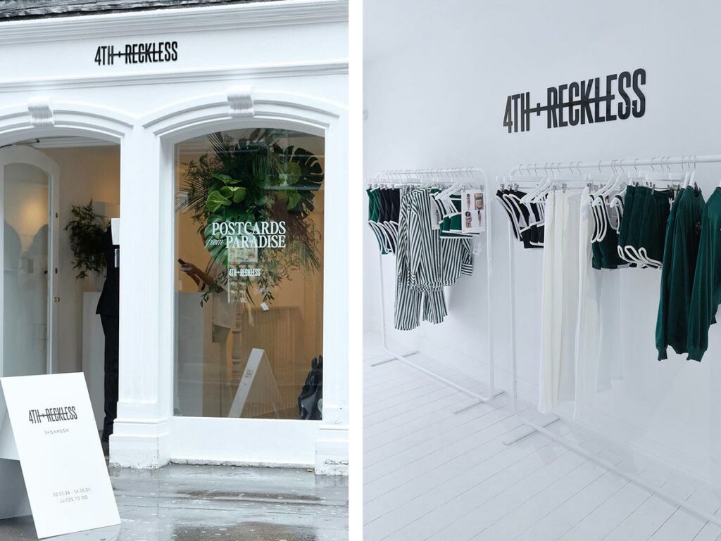 A modern pop-up store with clothing racks and a large central display table.