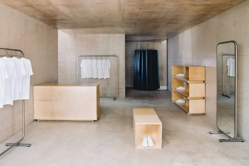 Modern event furniture set up with white chairs and tables in a spacious room.