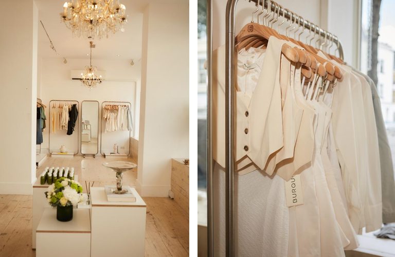 Elegant boutique interior with clothing and chandelier.