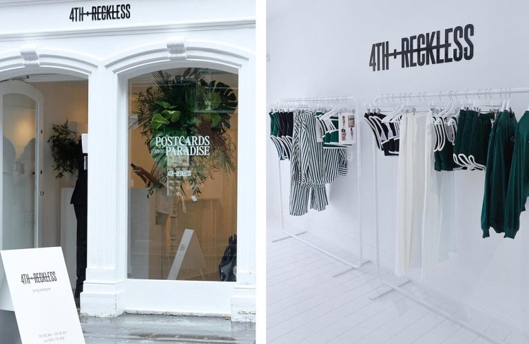 A modern pop-up store with clothing racks and a large central display table.