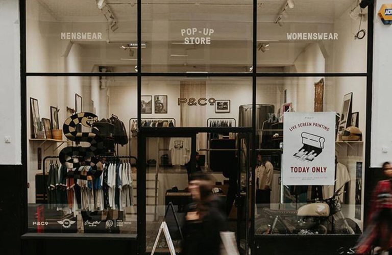 Boutique pop-up store front with menswear and womenswear sections.